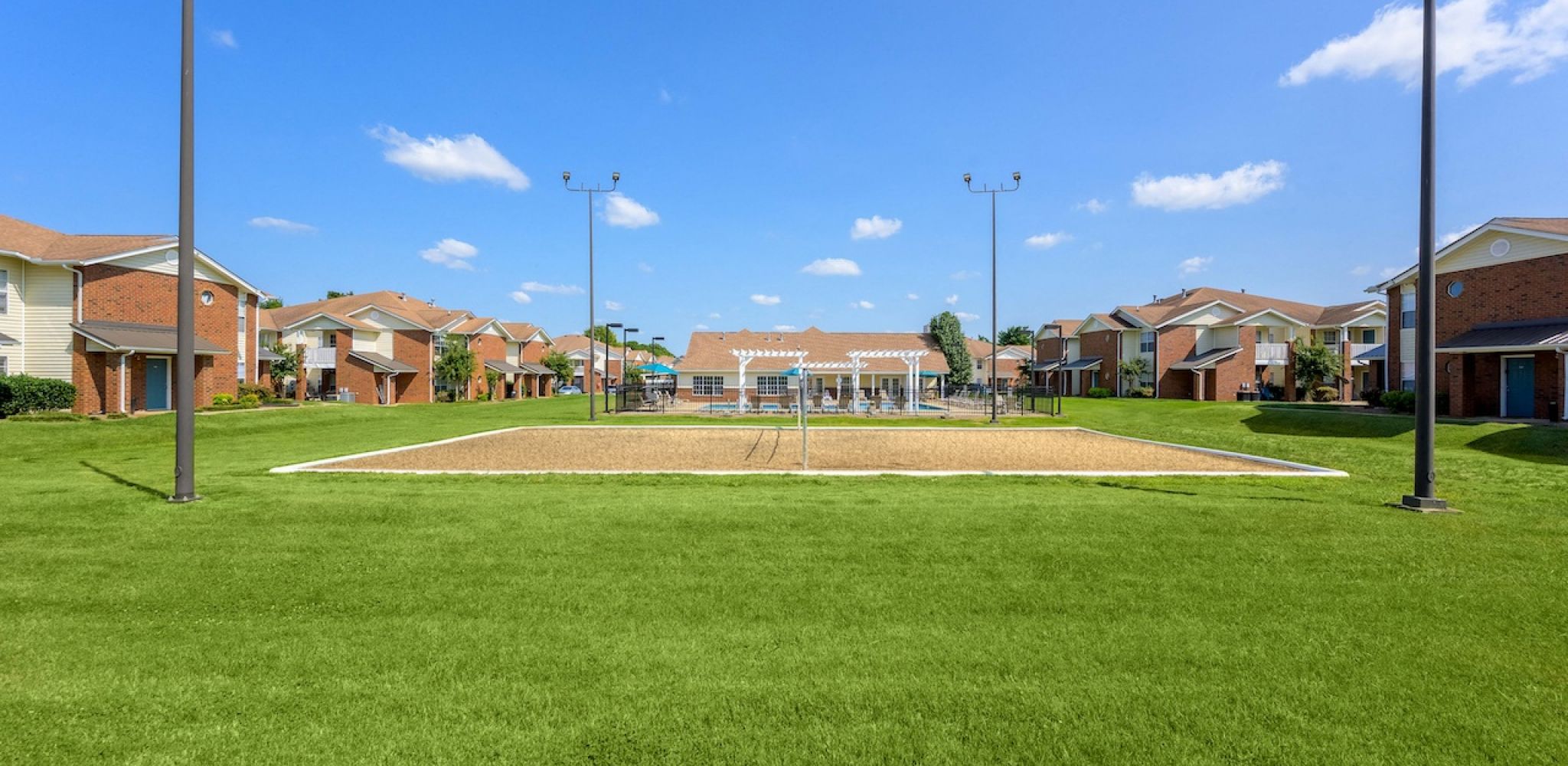 Hawthorne Park South apartment community exterior with volleyball court and pool area
