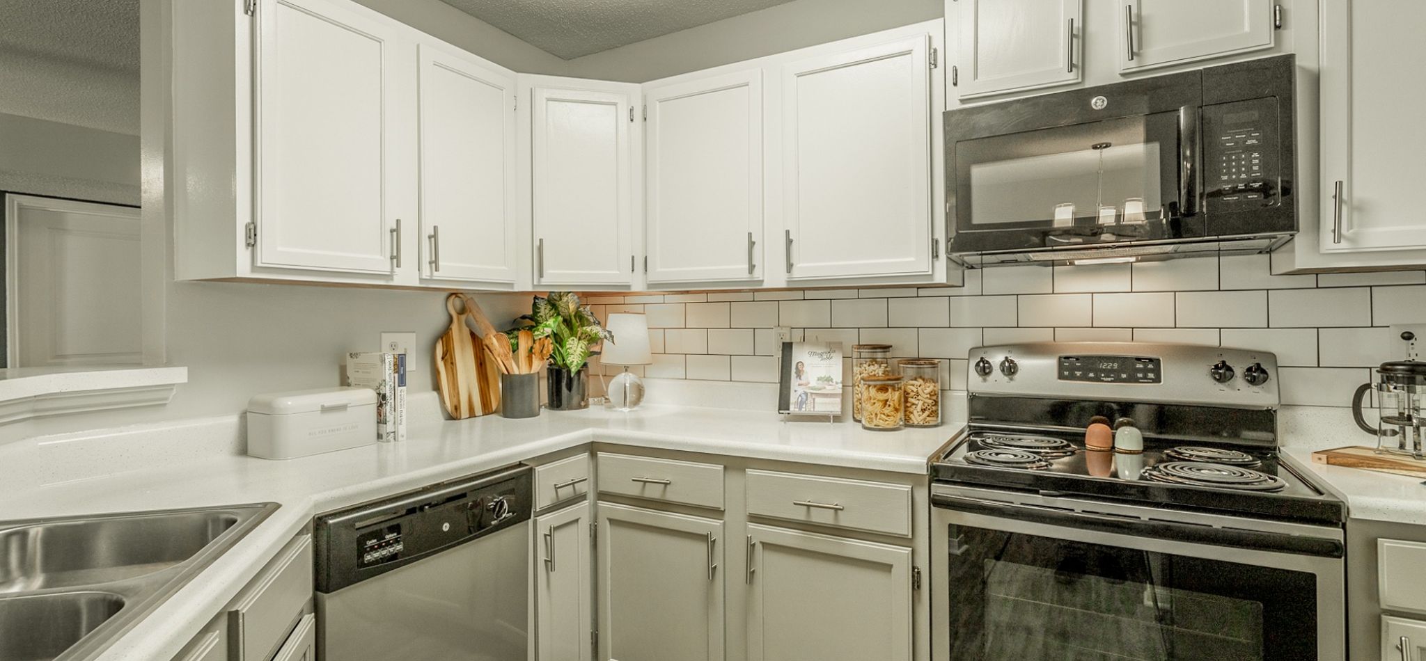 Hawthorne Park South apartment kitchen interior with tile backsplash, stainless steel appliances, and white cabinetry